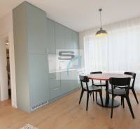 Dining area with a table and chairs, built-in cabinets, and a floor with a wood decor.