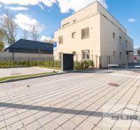 The exterior of the building on Železničná Street in Bratislava - Vrakuňa, with parking and greenery.