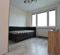 A room in a 3-room apartment, floor with wooden decor, sofa and dresser.