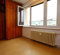 A room with wooden paneling and a radiator in a 3-room apartment.