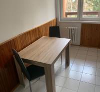 Dining area with a wooden decor table in a 2-room apartment.