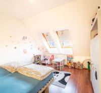 A children's room in a two-room apartment with skylights, furniture, and toys.
