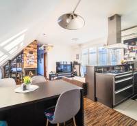 A kitchen with a TV, fireplace, and wooden decor flooring in a 2-room apartment.