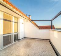 Sunny terrace by a 2-room apartment with a view of the rooftops and the sky.