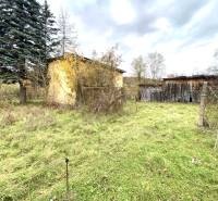 A family house in Rykynčice, surrounded by nature, next to wooden structures and trees.