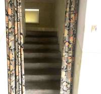 Concrete stairs in a family house, covered with a patterned curtain.