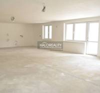 An empty interior of a family house with an unfinished floor and windows.