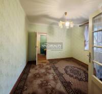 A room in a family house with a carpet, green walls, and decorative lighting.