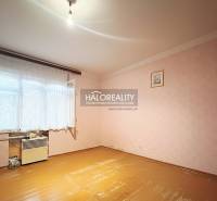 A room in a family house with a wooden decor floor and pink walls.