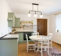 A kitchen in a family house with a wooden floor decor and a green kitchen unit.