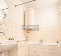 A bathroom in a family house with a bathtub, a sink, and a floor with a wooden design.