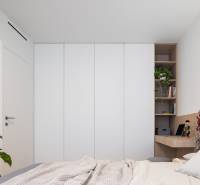 Bedroom in a 3-room apartment with a wardrobe, a plant, and a desk.