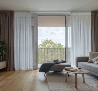 Living room with a sofa, wooden decor flooring, and a large window in a 3-room apartment.