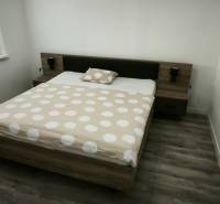 A bedroom with a double bed and a wooden decor floor in a 3-room apartment.