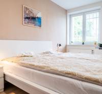 Bedroom in a 3-room apartment with a large bed, table lamps, and a bright interior.