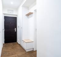 Bright hallway in a 3-room apartment with brown tiles and storage space.