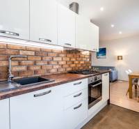 Kitchen in a 3-room apartment with brick wall cladding and a floor with wood decor.