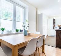Dining area with a table and plants in a 3-room apartment with a kitchen.