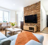 Living room with a sofa, table, and TV, in a 3-room apartment. Floor with wooden decor.