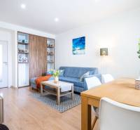 Living room in a 3-room apartment with a blue sofa and a wooden decor floor.