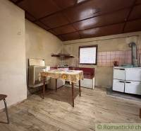 A kitchen in a family house with a wooden decor floor and simple furnishings.