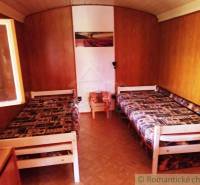 Wooden interior of a cabin with two beds and a floor with a wooden decor.