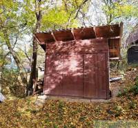 A small wooden cabin in the forest near Dudince, surrounded by autumn leaves.