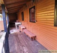 A cottage in Dudince with a veranda featuring a wooden decor floor and a bench.