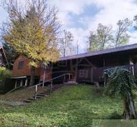A cottage in Dudince surrounded by nature with a terrace and trees in the yard.