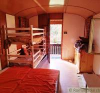 Interior of a cabin with four beds and a bright view of the terrace.