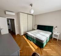 Bedroom with a bed, wardrobe, and wooden decor flooring in a 3-room apartment.