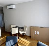 Dining area with a table, chairs, and a floor with wood decor in a 3-room apartment.