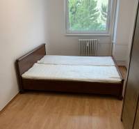 Bedroom in a 2-room apartment with a wooden decor floor and a double bed.