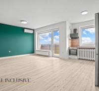 Living room with a kitchenette in a 2-room apartment and a floor with a wooden decor.