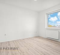 A bright room with wood-decor flooring and a window in a two-room apartment.