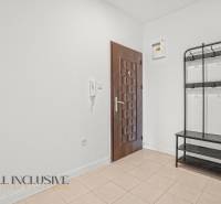 Spacious hallway in a 2-room apartment with tiles and a wall-mounted coat rack.