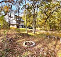 A cottage in the forest on Gazárka Street in Šaštín-Stráže surrounded by autumn trees and leaves.