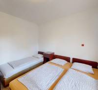 A bedroom in a cottage with one single bed and two joined beds, a space for relaxation.
