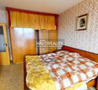 A bedroom in a 3-room apartment with decorative wallpaper and wooden furniture.