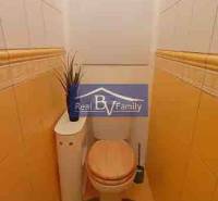 A toilet with beige walls and tiles in a 2-room apartment with decoration.