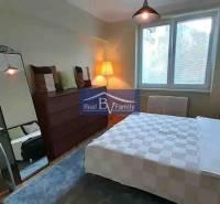 A bedroom in a 2-room apartment with a large mirror and a wooden decor floor.