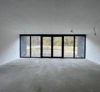 Spacious room with large windows in a family house, view of the garden.