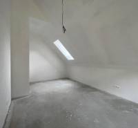 Attic room in a family house with a skylight and electrical outlets.