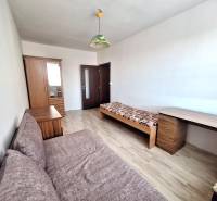 A room in a 3-room apartment with a wooden-decor floor, a bed, and a wardrobe.