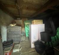 Storage space in a cottage in Šípkov with a decorative stove and various boxes.
