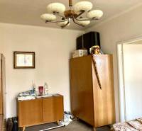 A room in a 3-room apartment with wooden furniture and a decorative chandelier.