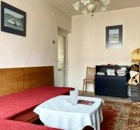 Living room in a 3-room apartment with a sofa, carpet, and decorative pictures on the wall.