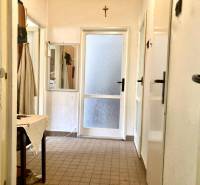 A hallway in a 3-room apartment with tiles, a mirror, and a canvas table.