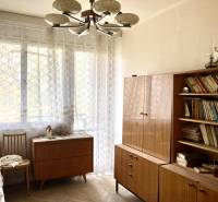 A room in a 3-room apartment with books, wooden furniture, and a floor with a wooden decor.