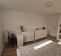 A bedroom in a 3-room apartment with a wood-decor floor, a built-in wardrobe, and a desk.